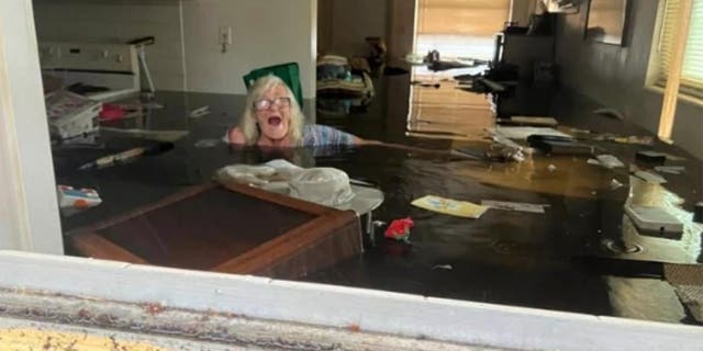 Johnny Lauder's mother, Karen Lauder, 86, is submerged nearly to her shoulders in water that has flooded her home, in Naples, Fla., Wednesday, Sept. 28, 2022, following Hurricane Ian.