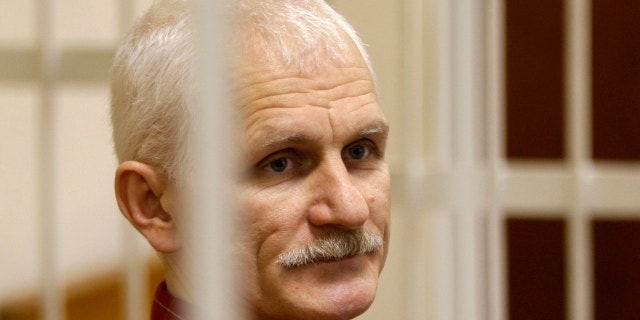 Ales Bialiatski, the head of Belarusian Vyasna rights group, stands in a defendants' cage during a court session in Minsk, Belarus, on Wednesday, Nov. 2, 2011.