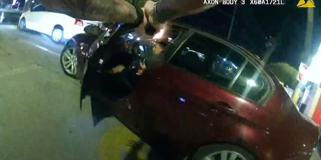 In this image taken from Oct. 2, 2022 police body camera video and released by San Antonio Police Department, San Antonio Police officer James Brennand shoots Erik Cantu, who was holding a hamburger in a fast food restaurant parking lot, as Cantu drives away in San Antonio, Texas.