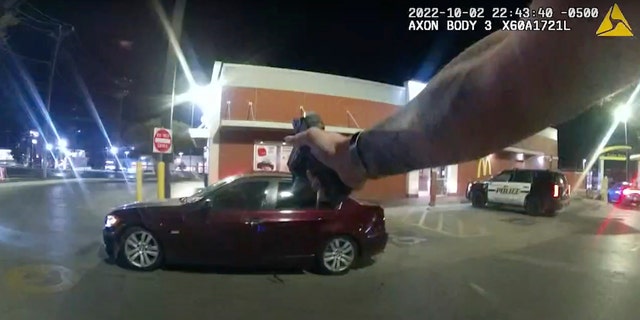 In this image taken from Oct. 2, 2022 police body camera video and released by San Antonio Police Department, Erik Cantu drives away as San Antonio Police officer James Brennand shoots his pistol at the car in a fast food restaurant parking lot in San Antonio, Texas. 