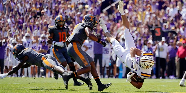 LSU tight end Mason Taylor, #86, is upended on a pass reception near the goal line by Tennessee defensive back Trevon Flowers, left, and defensive back Jaylen McCollough in the first half of an NCAA college football game in Baton Rouge, Louisiana, Saturday, Oct. 8, 2022. 