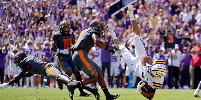 LSU tight end Mason Taylor, #86, is upended on a pass reception near the goal line by Tennessee defensive back Trevon Flowers, left, and defensive back Jaylen McCollough in the first half of an NCAA college football game in Baton Rouge, Louisiana, Saturday, Oct. 8, 2022.
