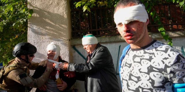 People receive medical treatment at the scene of Russian shelling, in Kyiv, Ukraine, Oct. 10, 2022. 