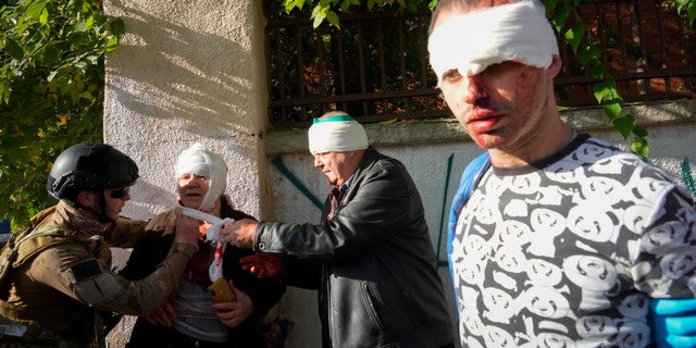 People receive medical treatment at the scene of Russian shelling, in Kyiv, Ukraine, Oct. 10, 2022.