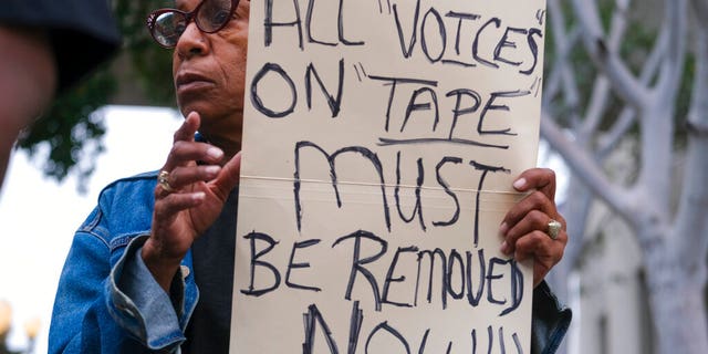 Veronica Sance holds a sign at a news conference to denounce racism and demand change in response to a recorded, racially charged leaked conversation between leaders at City Hall and the Los Angeles County. On Wednesday, the council committee censured council members Kevin de Leon, Gil Cedillo and former member Nury Martinez.