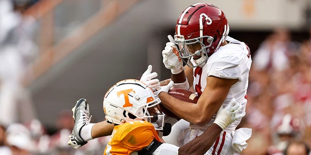 Alabama wide receiver Jermaine Burton (3) makes a catch as he is defended by Tennessee defensive end Christian Charles (14) during the second half of an NCAA college football game Saturday, Oct. 15, 2022, in Knoxville, Tennessee.  Tennessee won 52-49. 
