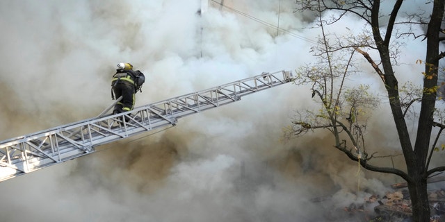 Firefighters work after a drone fired on buildings in Kiev, Ukraine on Monday, October 17, 2022.