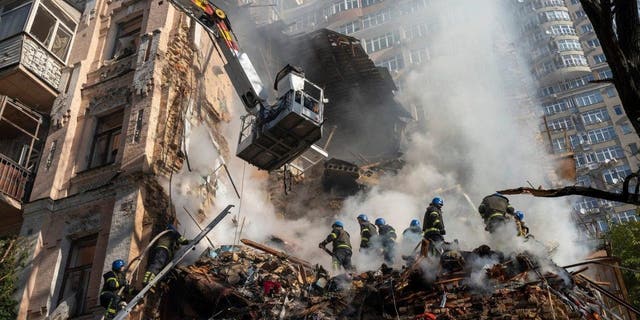 FILE - Firefighters work after drone strike on buildings in Kiev, Ukraine, October 17, 2022. As protests rage at home, Iran's theocratic government is increasingly showing its military muscle abroad. 