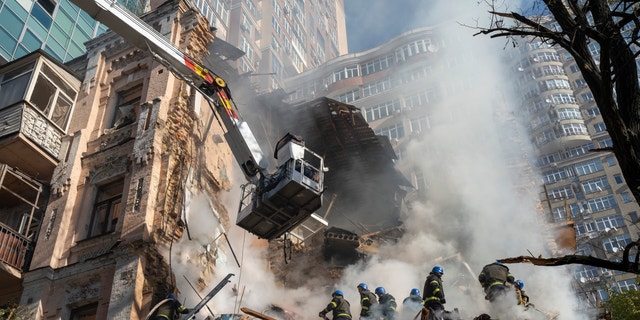Firefighters work after a drone attack on buildings in Kyiv, Ukraine, Oct. 17, 2022. 