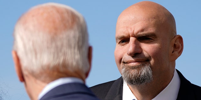 Pennsylvania Lt. Gov. John Fetterman, a Democratic candidate for U.S. Senate, stands on the tarmac after greeting President Biden, front left, Thursday, Oct. 20, 2022, at the 171st Air Refueling Wing at Pittsburgh International Airport in Coraopolis, Pa. Biden is visiting Pittsburgh to promote his infrastructure agenda.