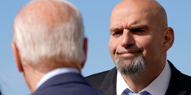 Pennsylvania Lt. Gov. John Fetterman, a Democratic candidate for U.S. Senate, stands on the tarmac after greeting President Biden, front left, Thursday, Oct. 20, 2022, at the 171st Air Refueling Wing at Pittsburgh International Airport in Coraopolis, Pa. Biden is visiting Pittsburgh to promote his infrastructure agenda.