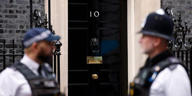 Two policemen stand guard near the front door to 10 Downing Street the official home of the British Prime Minister in London, Friday, Oct. 21, 2022. 