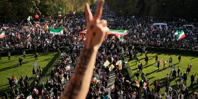 A man gestures as people attend a protest against the Iranian regime, in Berlin, Germany, Saturday, Oct. 22, 2022, following the death of Mahsa Amini in the custody of the Islamic republic's notorious "morality police."