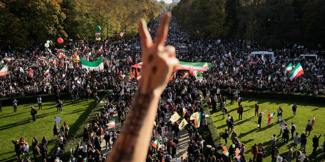 A man makes gestures as people participate in a protest against the Iranian regime, in Berlin, Germany, on Saturday 22 October 2022, following the death of Mahsa Amini in the custody of the infamous "moral police."