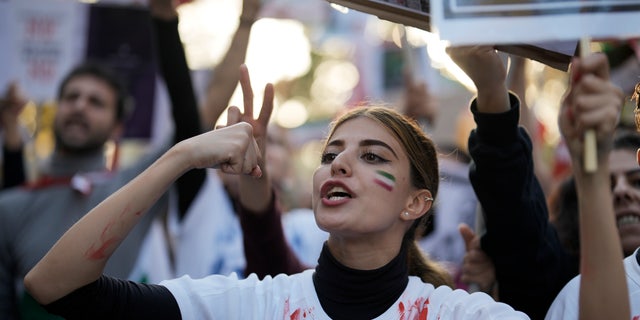 A woman shouts during a protest against the Iranian regime, in Berlin, Germany, Saturday, Oct. 22, 2022, following the death of Mahsa Amini in the custody of the Islamic republic's notorious "morality police."