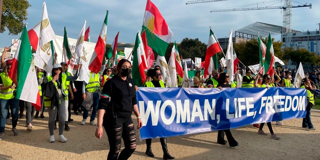 People carry a sign that reads "Woman, Life, Freedom," as hundreds rally on Saturday, Oct. 22, 2022, in Washington in a show of international support for demonstrators facing a violent government crackdown in Iran, sparked by the death of 22-year-old Mahsa Amini in the custody of that country's morality police. 