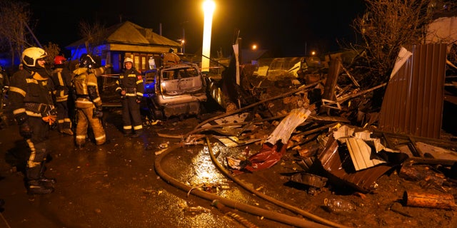 Firefighters work at the scene after a warplane crashes in a residential area in Irkutsk, Russia, Sunday, October 23, 2022.