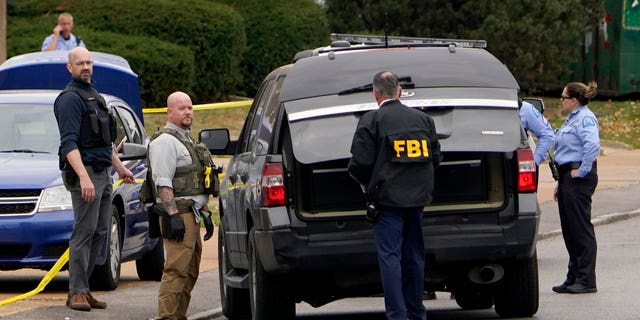 Law enforcement personnel investigate the scene of a shooting at Central Visual and Performing Arts High School, Oct. 24, 2022, in St. Louis.