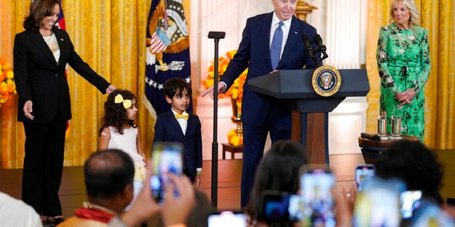 Il presidente Joe Biden parla dopo aver invitato due bambini sul palco durante un evento per celebrare il Diwali, nella Sala Est della Casa Bianca, lunedì. Il vicepresidente Kamala Harris, a sinistra, e la first lady Jill Biden, a destra, guardano.