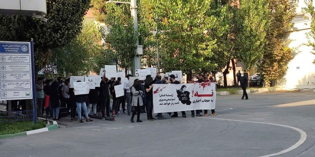 In this photo taken by an individual not employed by the Associated Press and obtained by the AP outside Iran shows students of the Sharif University of Technology attend a protest sparked by the death in September of 22-year-old Mahsa Amini in the custody of the country's morality police, in Tehran, Friday, Oct. 7, 2022. The banner says: 