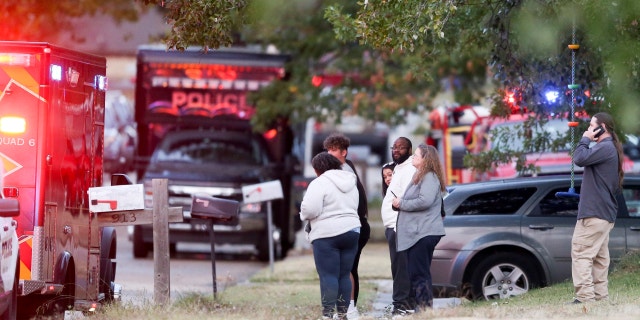 People look on as Broken Arrow, Okla., police and fire department investigate the scene of a fire with multiple fatalities.