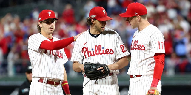 Aaron Nola (27) of the Philadelphia Phillies talks with Bryson Stott (5) and Rhys Hoskins (17) on the mound during the seventh inning against the Atlanta Braves in Game 3 of the National League Division Series at Citizens Bank Park Oct. 14, 2022, in Philadelphia.