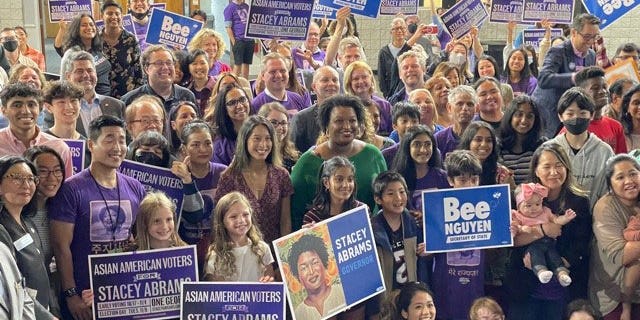 Democratic Georgia gubernatorial nominee Stacey Abrams poses for a photo with attendees of a rally in support of her campaign, as well as Democratic Georgia Secretary of State nominee Bee Nguyen (picture to the left of Abrams), in Gwinnett County on October 7, 2022.
