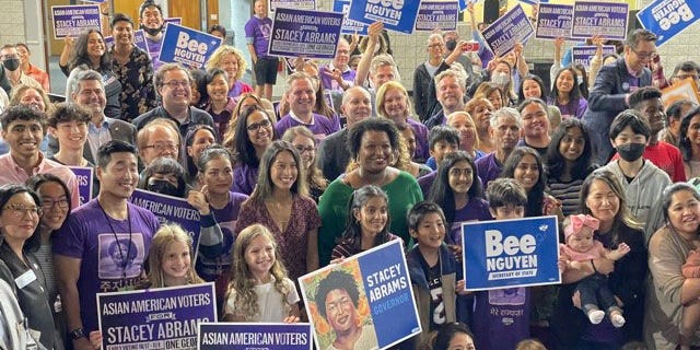 Democratic Georgia gubernatorial nominee Stacey Abrams poses for a photo with attendees of a rally in support of her campaign, as well as Democratic Georgia Secretary of State nominee Bee Nguyen (picture to the left of Abrams), in Gwinnett County on October 7, 2022.