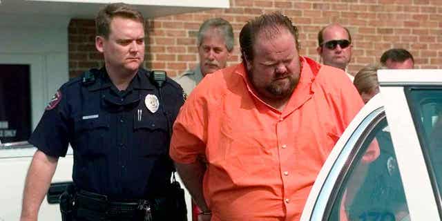 Officials escort murder suspect Alan Eugene Miller away from the Pelham City Jail in Alabama, on Aug. 5, 1999. Miller claimed prison staff poked him with needles for over an hour during a failed lethal injection attempt in September 2022. 