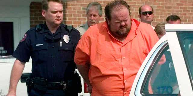 Officials escort murder suspect Alan Eugene Miller away from the Pelham City Jail in Alabama, on Aug. 5, 1999. Miller claimed prison staff poked him with needles for over an hour during a failed lethal injection attempt in September 2022. 