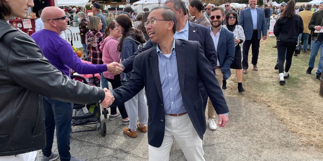 Allan Fung, the Republican nominee in the 2nd Congressional District, shakes hands with voters at the Scituate Art Festival, on Oct. 10, 2022, in North Scituate, Rhode Island.