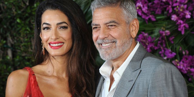 Amal and George Clooney smile for a photo
