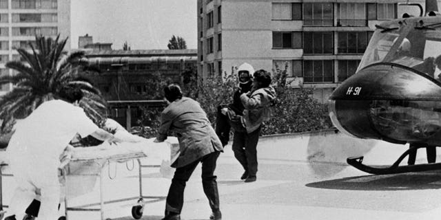 Helicopter crew members transport the survivor of the Uruguayan plane crash on October 13 on a stretcher to the helipad of the Santiago Central Emergency Station.  The survivor, one of the 16, was flown to the capital directly from the crash site in the Andes.  (Photo by Bettmann Archive / Getty Images)