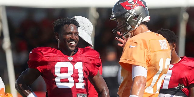 Antonio Brown (81) of the Buccaneers smiles as he talks with Tom Brady (12) during a joint training camp with the Tennessee Titans Aug. 18, 2021, at the AdventHealth Training Center at One Buccaneer Place in Tampa, Fla.