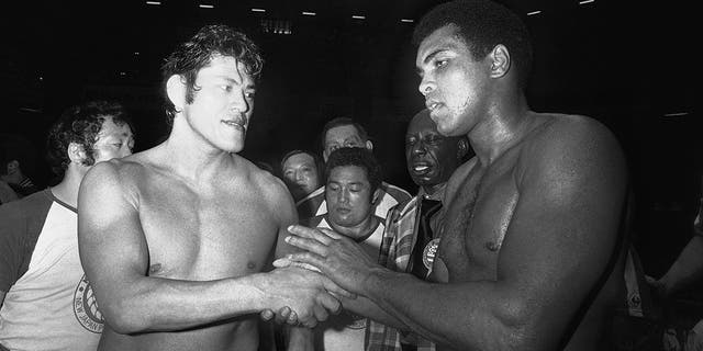 Wrestler Antonio Inoki, left, and world heavyweight boxing champion Muhammad Ali shake hands after a 15-round boxing-wrestling fight on June 26, 1976, at Tokyo's Budokan.