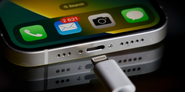 An Apple Lightning port charging cable is seen with an iPhone in this illustration photo, in Warsaw, Poland on Oct. 5, 2022.