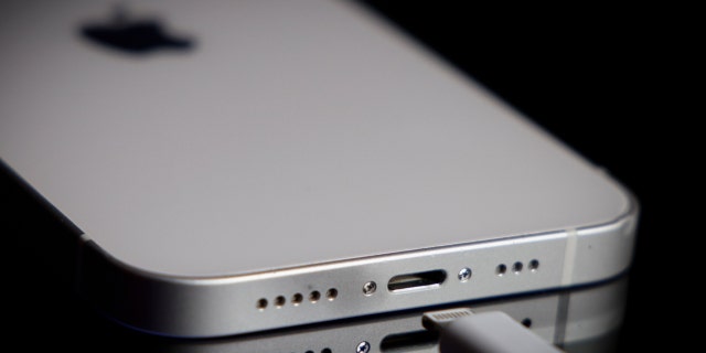 An Apple Lightning port charging cable is seen in use with an iPhone in this illustration photo taken on October 5, 2022 in Warsaw, Poland.