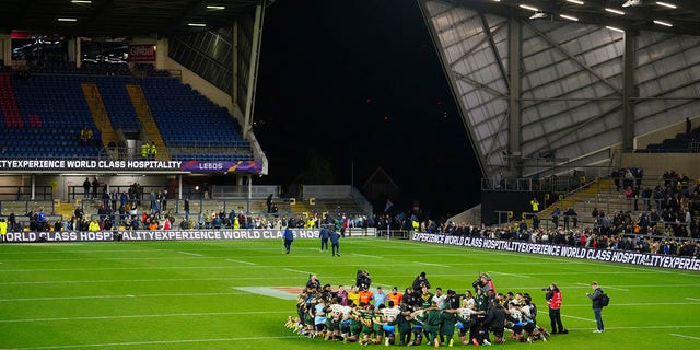 Fiji's players and team members pray at the end of the Rugby League World Cup match between Australia and Fiji at the Headingley Stadium, Leeds, England, Saturday, Oct. 15, 2022.