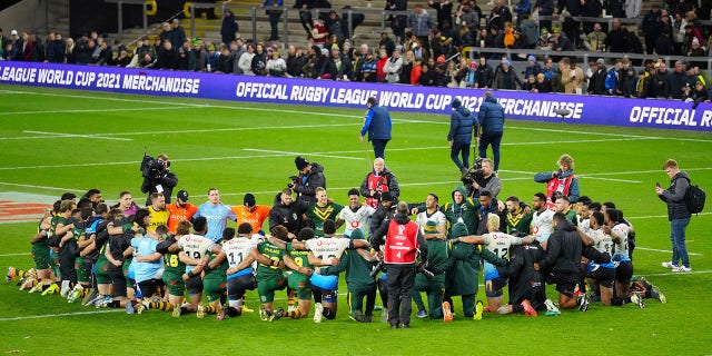 Fiji's players and team members pray at the end of the Rugby League World Cup match between Australia and Fiji at the Headingley Stadium, Leeds, England, Saturday, Oct. 15, 2022.