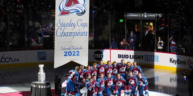 Avalanche raise Stanley Cup banner, start title defense with win 3 Members of the Colorado Avalanche pose with the championship banner before it is hoisted into the arena Wednesday, Oct. 12, 2022 in Denver.