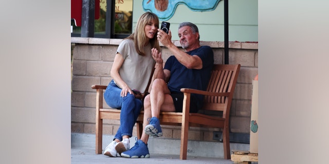 Sylvester Stallone, 76, and his wife Jennifer Flavin, 54, are seen laughing on a bench as teenagers in Calabasas, California. 