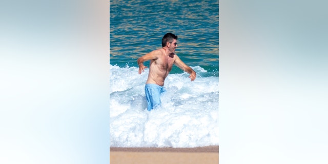 Simon Cowell was seen vacationing in Cabo with his socialite fiancée Lauren Silverman and their 8-year-old son, Eric.