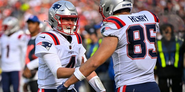 New England Patriots quarterback Bailey Zappe (4) celebrates after throwing a touchdown pass to tight end Hunter Henry (85) during the second half of an NFL football game against the Cleveland Browns, Sunday, Oct. 16, 2022, in Cleveland. 