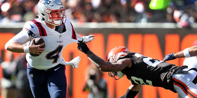 New England Patriots quarterback Bailey Zappe avoids a sack by Cleveland Browns' Grant Delpit.