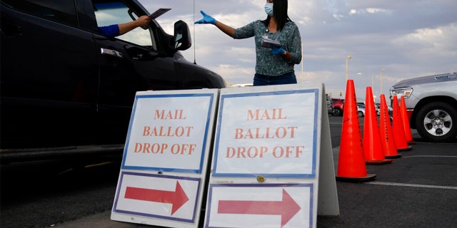 A county worker collects mail-in ballots in a drive-thru ballot drop off area at the Clark County Election Department in Las Vegas.