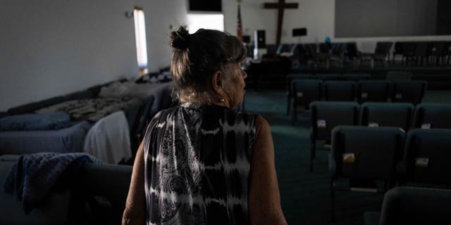 Barbara Wasko walks through the sanctuary of the Southwest Baptist Church in Fort Myers, Fla., Sunday, Oct. 2, 2022. She took refuge inside the church when Hurricane Ian swept through Southwest Florida. (AP Photo/Robert Bumsted)