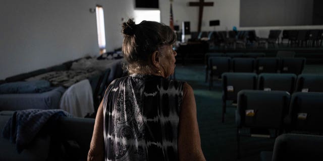 Barbara Wasco walks through the sanctuary of Southwest Baptist Church in Fort Myers, Florida on October 2, 2022. When Hurricane Her Ian hit Southwest Florida, she took refuge inside a church.  (AP Photo/Robert Bumsted)