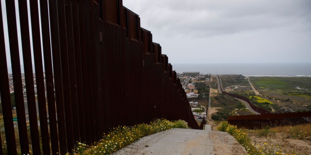 New sections of the steel bollard-style border wall, comprising primary and secondary barriers, stands along the US-Mexico border between San Diego and Tijuana (L) during a tour with US Customs and Border Protection (CBP) on May 10, 2021 in the Otay Mesa area of San Diego County, California. - Few issues have as long a history of bedeviling both Democrats and Republicans as immigration and asylum on the approximately 2,000-mile (3,000-kilometer) US-Mexico frontier. 