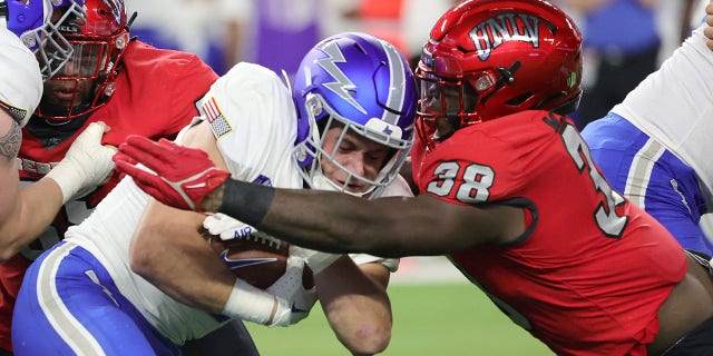 Running back Brad Roberts #20 of the Air Force Falcons is tackled by linebacker Marsel McDuffie #38 of the UNLV Rebels during their game at Allegiant Stadium on October 15, 2022, in Las Vegas, Nevada.