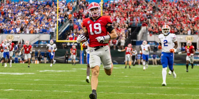 JACKSONVILLE, FLORIDA - OCTOBER 29: Brock Bowers #19 of the Georgia Bulldogs catches a pass and runs into the end zone for a touchdown during the first half of a game against the Florida Gators at TIAA Bank Field on October 29, 2022 in Jacksonville, Florida.